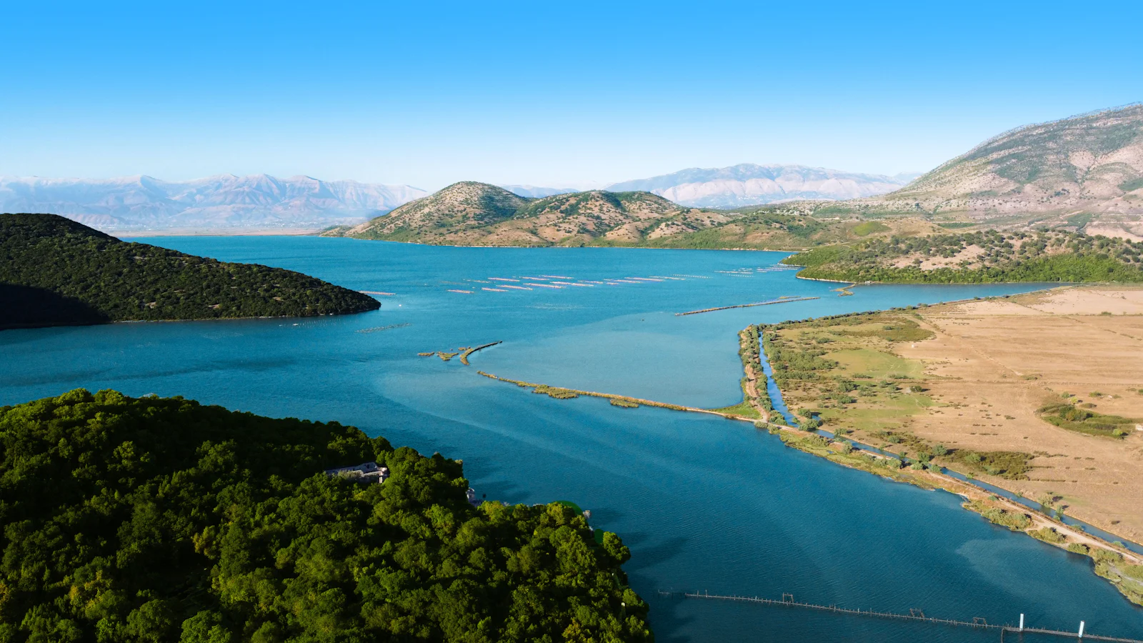 Butrint Lagoon with the lines of the mussel farms, hills behind